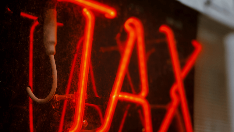 Leuchtschrift "Taxes": Vorab-Steuer auf ETFs und Fonds: Was jetzt zu tun ist