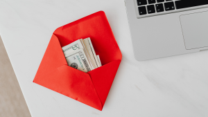 Roter Umschlag mit vielen Geldscheinen: Sparen mit Cash Stuffing