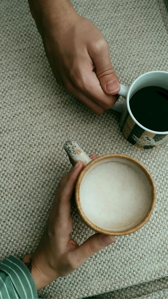 Zwei Hände halten zwei Kaffeetassen
