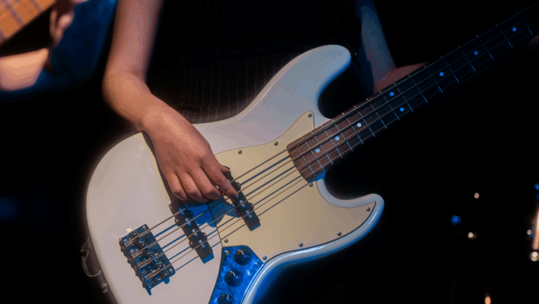 Weiße Gitarre und eine weibliche Hand, die an einer Seite zupft