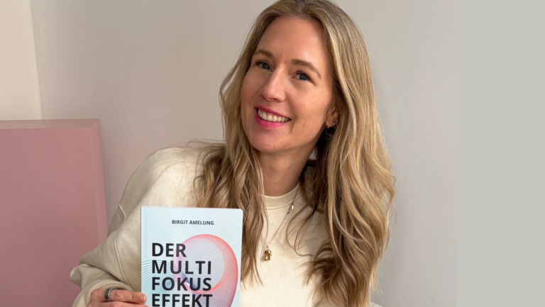 Birgit Amelung hält ihr neues Buch "Der Multi-Fokus-Effekt" in die Kamera
