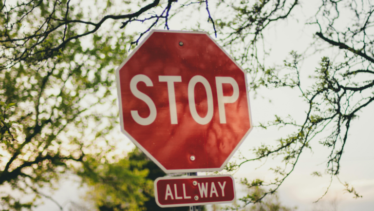 Ein Stop-Schild zwischen Ästen, darunter steht "All Way"