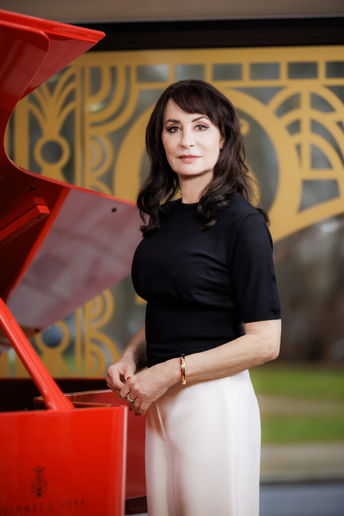Anna Maria Kaufmann steht vor einem roten Flügel