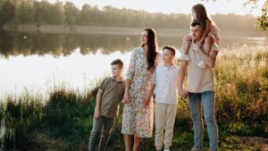 Eine Familie steht an einem See und schaut in die Ferne