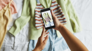 Ein Handy, das auf dem Fotodisplay einen Kleiderstapel zeigt, den es gerade fotografiert
